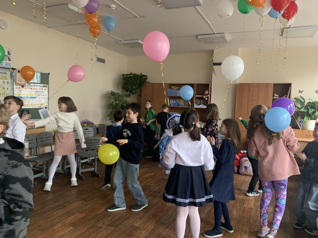 Школьный праздник — дети с воздушными шарами в классе